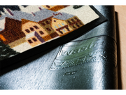 Rückenansicht der mehrfarbigen Fußmatte mit roter Berg-Gondel in einem winterlichen Tal