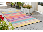 Fußmatte mit bunten Streifen im Gartenbereich