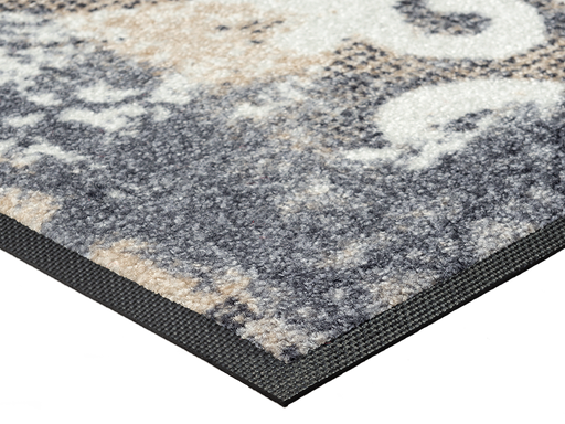 Eckansicht der Fußmatte mit hellgrauen, beigen und weißen geschwungenen Ornamenten