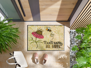 Fußmatte mit Blume und Biene und Schriftzug "don´t worry, be happy" vor der Tür