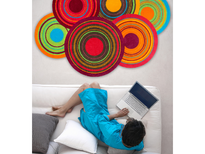 Fußmatte in Sonderform mit bunten Kreisen vor dem Sofa