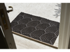 Fußmatte mit dunkelbraunen, halbrunden Linien vor der Tür