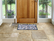 graue Fußmatte mit farbigen Dreiecken vor der Tür