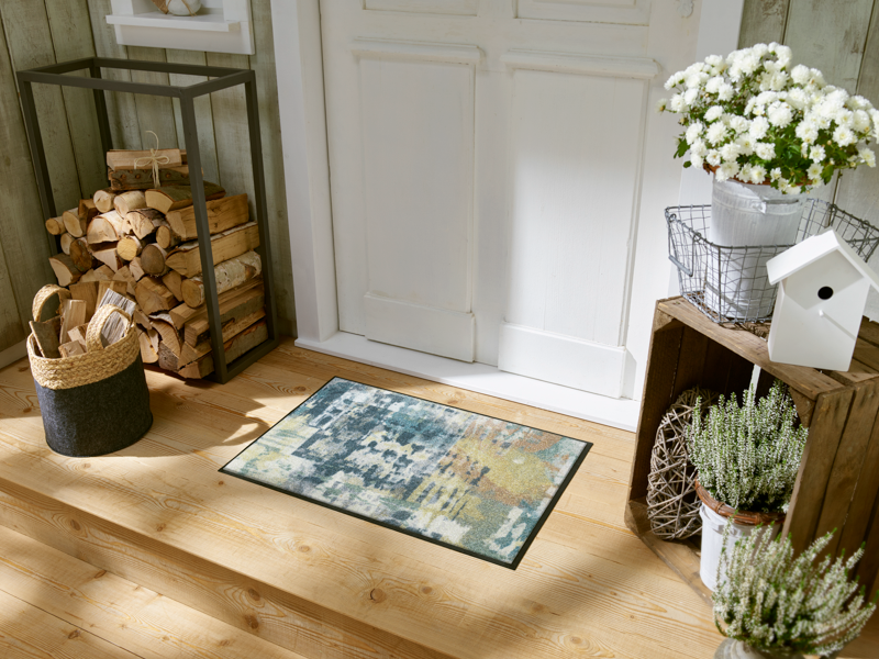 Fußmatte mit blau, grünem abstraktem Muster vor der Haustür