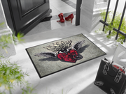 Fußmatte mit Herz und Flügeln vor der Tür