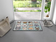 Fußmatte mit Katzenköpfen vor der Tür