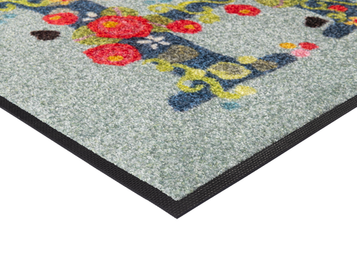Eckansicht der Fußmatte mit Schriftzug "HI" mit Blumen geschmückt