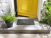 Fußmatte in grau mit Häusermotiv vor der Tür