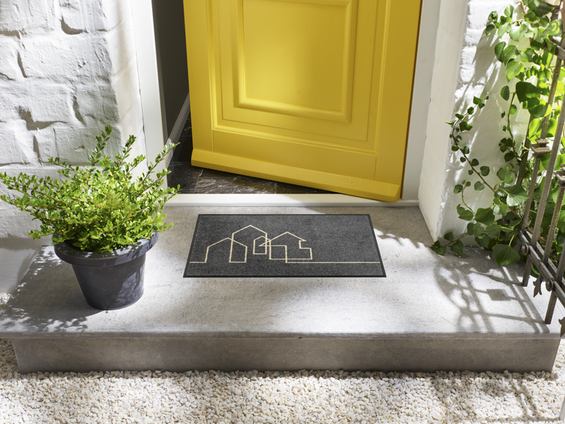 Fußmatte in grau mit Häusermotiv vor der Tür