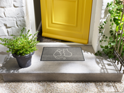 Fußmatte mit Katzenformen in grau vor der Eingangstür