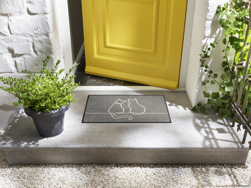 Fußmatte mit Katzenformen in grau vor der Eingangstür