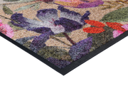 Eckansicht der Fußmatte in schwarz mit buntem, violettem Blumenmotiv