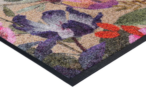 Eckansicht der Fußmatte in schwarz mit buntem, violettem Blumenmotiv