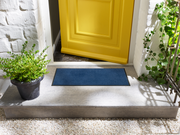 dunkelblaue Fußmatte vor der Tür