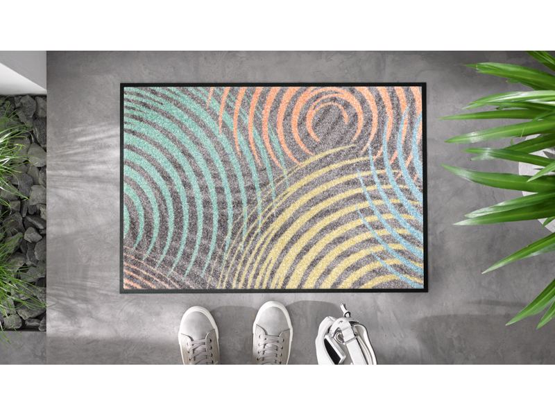 Fußmatte mit bunten Kreisformen auf dem Boden