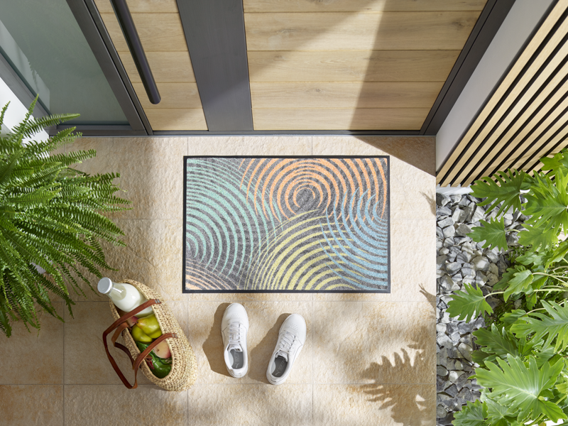 Fußmatte mit bunten Kreisformen vor der Haustür