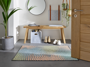 Fußmatte mit bunten Kreisformen vor der Tür und Garderobe