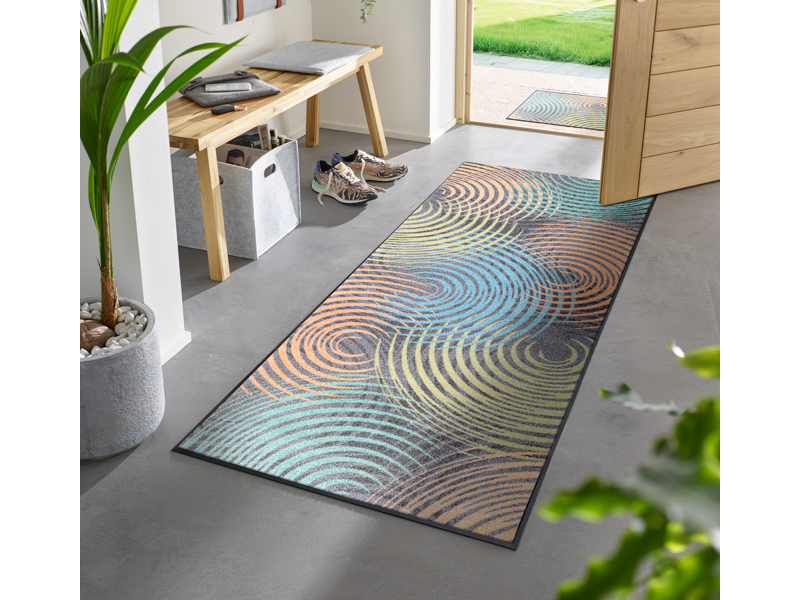 Läufer mit bunten Kreisformen vor der Eingangstür