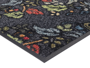 Eckansicht der Fußmatte in grau mit buntem floralen Ornamenten