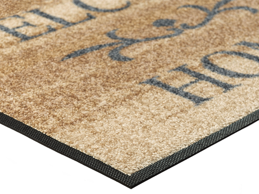 Eckansicht der hellbraunen Fußmatte mit Ornament und Schriftzug "WELCOME HOME"