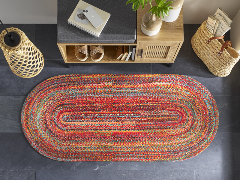 Fußmatte in Sonderform mit rot-bunten Punkten in der Garderobe