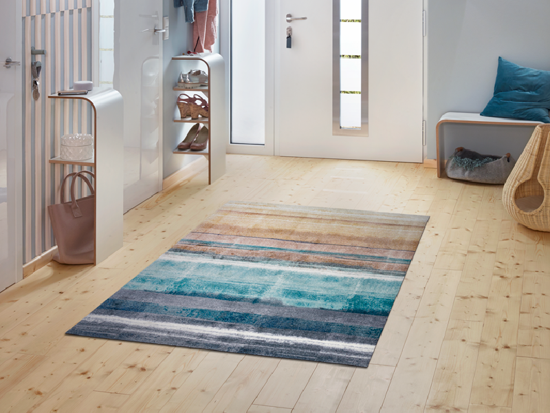 Fußmatte mit blau-beigen Streifen im Eingangsbereich