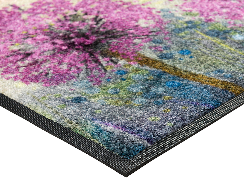 Eckansicht der Fußmatte mit lilafarbenen Blumen