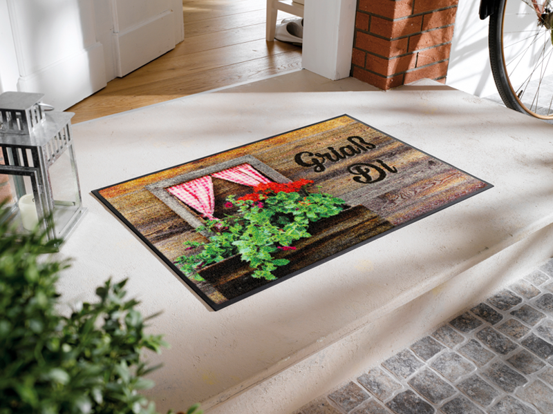 Fumatte mit Almhütte und Spruch "Griaß Di" vor der Tür