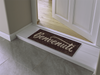 braune Fußmatte mit Schriftzug "Benvenuti" vor der Tür