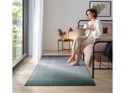 Fußmatte mit grün-schwarzer und dezenter Musterung im Schlafzimmer mir einer Frau