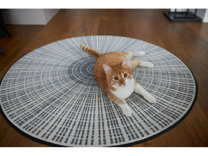 runde Fußmatte mit grau, weißer Linienstruktur und einer Katze
