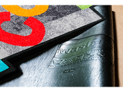 Rückenansicht der Fußmatte in spezieller Form mit bunten, tanzenden Buchstaben "WELCOME"