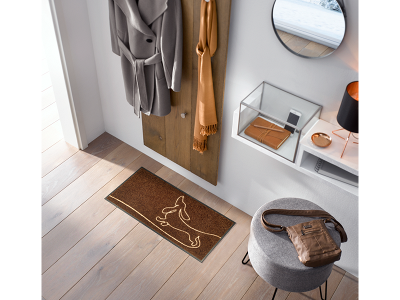 braune Fußmatte mit liniengezeichnetem Dackel-Hund in der Garderobe