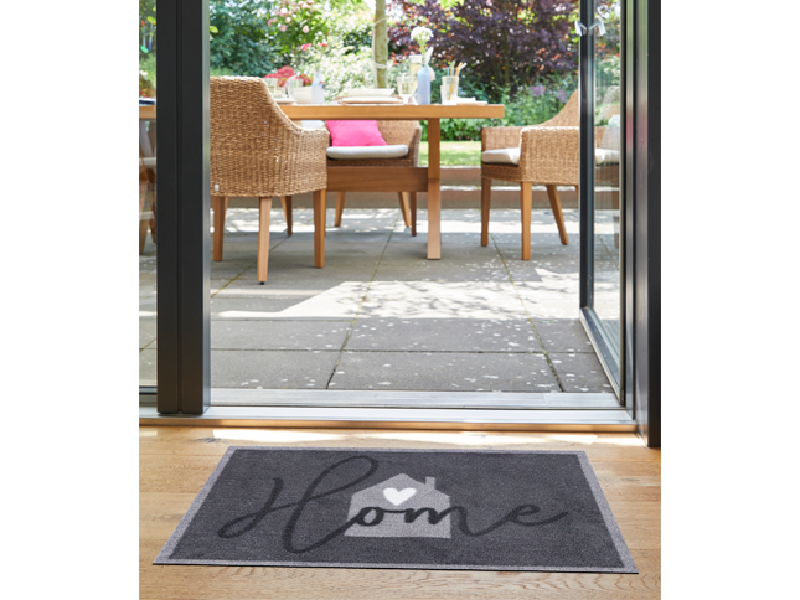 Fußmatte mit Haus und Schriftzug "Home" im Eingangsbereich