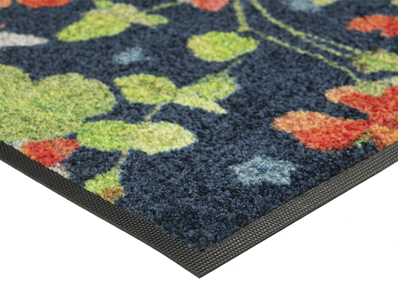 Eckansicht der Fußmatte mit roten Blumen und grünen Blumenstängeln und Bienen auf dunkelblauem Hintergrund