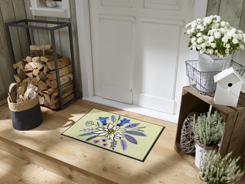 Fußmatte mit Alpenblumen-Motiv vor der Eingangstür