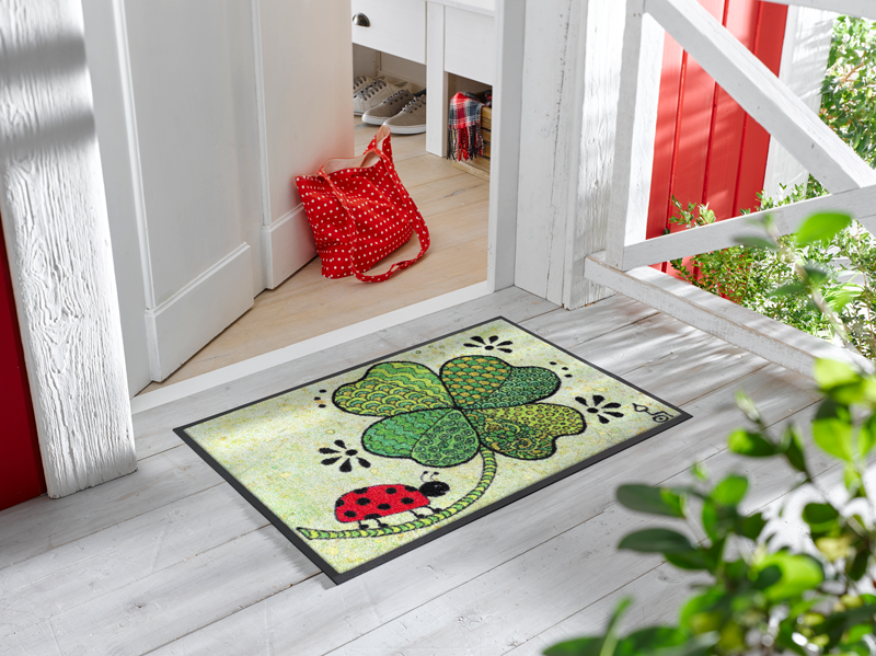 Fußmatte mit Klee und Marienkäfer vor der Eingangstür