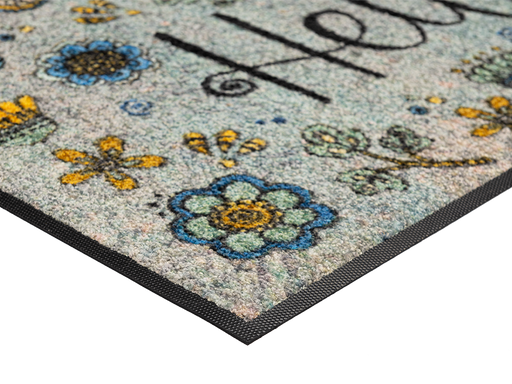 Eckansicht der Fußmatte mit Blütenmotiven, Schmetterling, Libelle und Schriftzug "Hello"