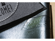 Rückenansicht der grauen Fußmatte mit Schriftzug "WELCOME!" und Hundemotiv