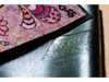 Rückenansicht der Fußmatte mit Schriftzug "Hier wohnt das Glück" und gemalten Blumen-Tiermotiven