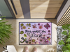 Fußmatte mit Schriftzug "Hier wohnt das Glück" und gemalten Blumen-Tiermotiven vor der Tür