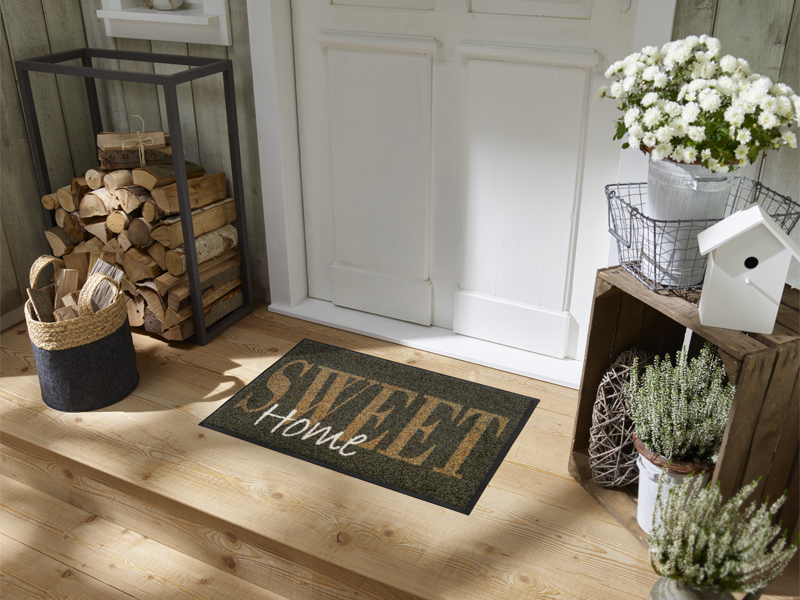 Fußmatte in braun mit Aufschrift "SWEET Home" vor der Eingangstür