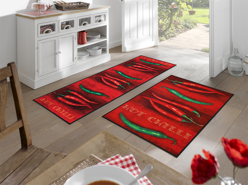 rote Fußmatten mit Chilis und Schriftzug "Hot Chilli" im Eingangsbereich