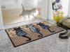 Fußmatte mit drei Katzen und Ornamenten vor der Tür