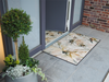 Fußmatte mit dezentem Blütendesign vor der Tür