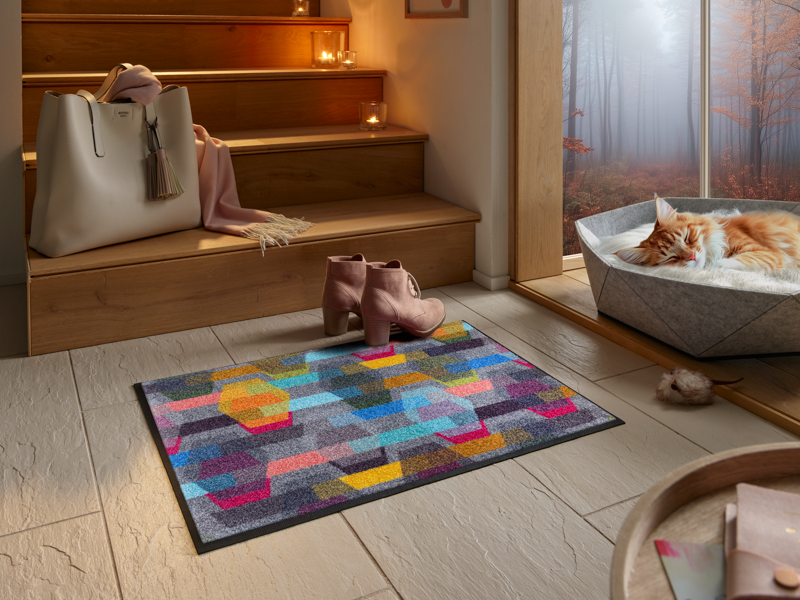 Fußmatte mit buntem geometrischem Muster vor der Treppe