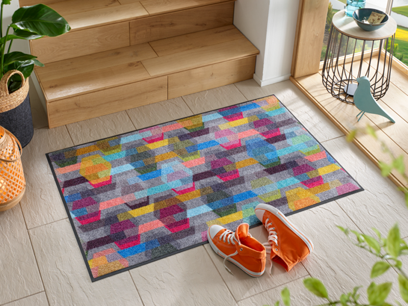 Fußmatte mit buntem geometrischem Muster vor der Treppe