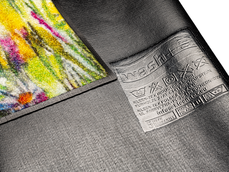 Rückendetail der Fußmatte mit Kuh und Blumenwiese