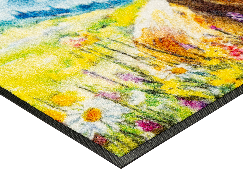 Eckdetail der Fußmatte mit Kuh und Blumenwiese