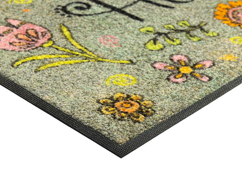 Eckansicht der Fußmatte mit Blütenmotiven, Biene und Schriftzug "Home"